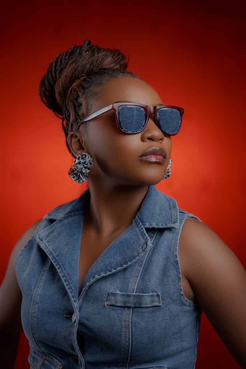 Editorial portrait in denim against a red background
